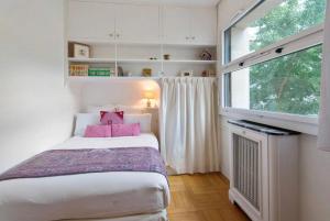 a small bedroom with a bed and a window at Avenue Montaigne Paris Bienvenue in Paris