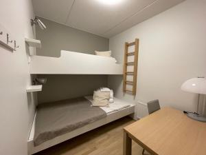 Cette chambre comprend 2 lits superposés et une table. dans l'établissement R-Chalet Ruka (2302), à Ruka