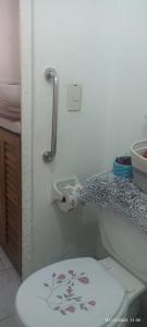 een badkamer met een toilet en een toilethouder bij ZIHUA TAANAJ in Zihuatanejo