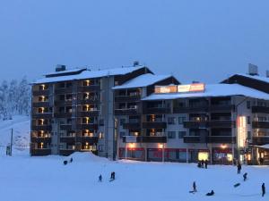 a group of people in the snow in front of a building at R-Chalet Ruka (2302) in Ruka