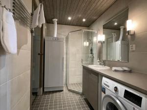 een badkamer met een wasmachine en een wastafel bij R-Chalet Ruka (2302) in Ruka