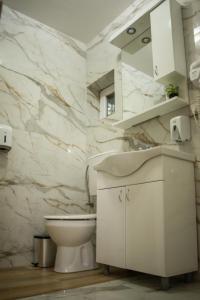 Baño blanco con aseo y lavamanos en La Mirage en Šabac
