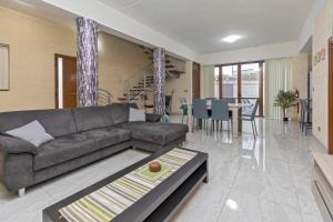 un soggiorno con divano e tavolo di 5 Bedroom Holiday Home with Private Pool a Xewkija