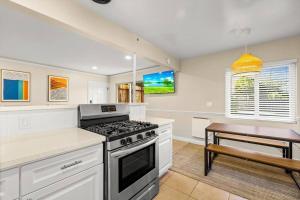 a kitchen with a stove top oven next to a table at 2 bedroom with bunk room and private yard for pets in Santa Barbara