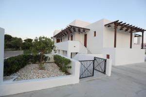 a white house with a gate and a driveway at George SkyrosStudios in Skiros