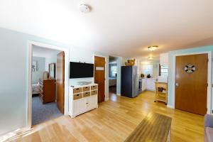 a living room with a television and a kitchen at Sea View Revue - A in Dennis Port