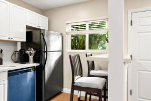a kitchen with a stainless steel refrigerator and two chairs at Beach Apartment Walk Downtown in Santa Barbara