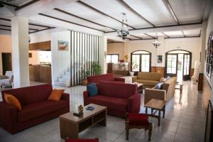 a living room with red couches and a table at Kefalonia Beach Hotel & Bungalows in Lixouri