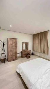 a bedroom with a white bed and a tripod at شقة جديدة ومميزة بحي الملقا in Riyadh
