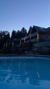 una piscina davanti a una casa di notte di Kras Resort Apartament 110 z prywatnym jacuzzi i widokiem na góry a Szklarska Poręba