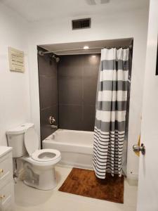 ein Badezimmer mit einem WC und einer Badewanne mit einem Duschvorhang in der Unterkunft Foresight Chalet Talbot in Leamington