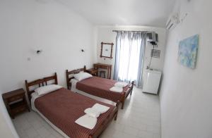 a hotel room with two beds and a window at Kefalonia Beach Hotel & Bungalows in Lixouri