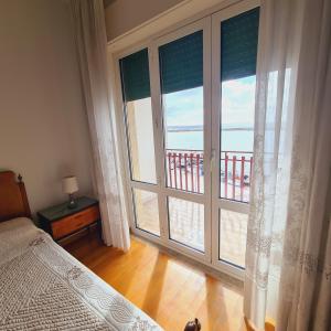 a bedroom with a large window with a view of the ocean at Un Letto sul Mare (vit vit vit) in Marsala