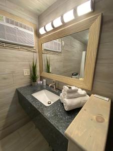 a bathroom with a sink and a mirror at American Inn in Pensacola