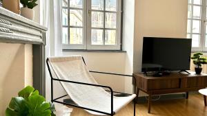a living room with a chair and a flat screen tv at Élégance et Cathédrale in Nevers