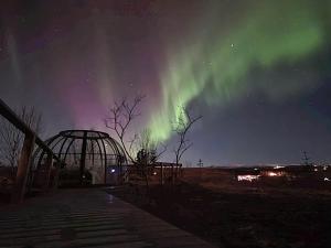 an image of the aurora dancing in the sky at Cottage with Glass Bubble and Hot tub in Reykholt