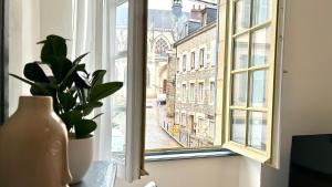 a vase sitting next to a window with a view at Élégance et Cathédrale in Nevers