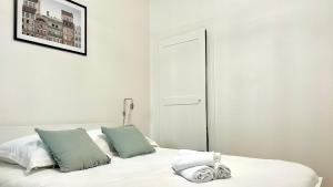 a bedroom with a white bed with two pillows at Élégance et Cathédrale in Nevers