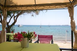 a view of the ocean from a table with flowers at Kefalonia Beach Hotel & Bungalows in Lixouri