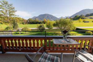 a table and chairs on a balcony with a view at Ferienwohnungen Schweiger in Ruhpolding