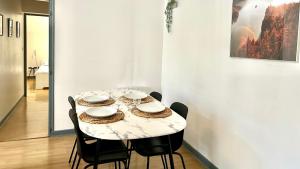 una mesa en una habitación con sillas y una mesa con platos en Élégance et Cathédrale, en Nevers