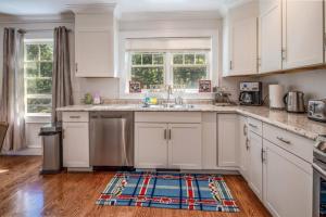 a kitchen with white cabinets and a rug on the floor at Quiet, Pet Friendly, close to Edgartown and Oak Bluffs in Edgartown