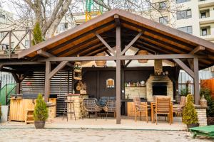 um pavilhão com uma mesa e cadeiras e uma lareira em Hanul Anei - entire property em Brasov