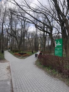 a path in a park with trees and a sign at TeoFeelLove in Łódź