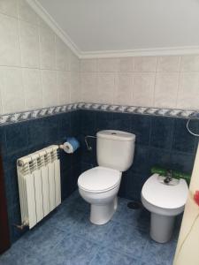 a bathroom with a toilet and a bidet and a radiator at Viviendas Vacacionales Beni II in Llanes