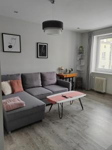 una sala de estar con un sofá y una mesa en Apartament Paderewskiego, en Kielce
