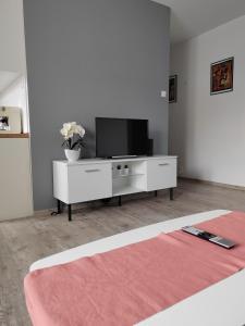 una sala de estar con TV en un armario blanco en Apartament Paderewskiego, en Kielce