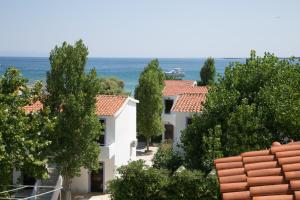 a view of houses with trees and the ocean at Kefalonia Beach Hotel & Bungalows in Lixouri