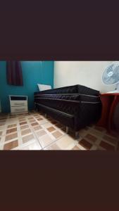 um quarto com uma cama preta e piso em madeira em Casa Temporada peterle Iriri em Iriri