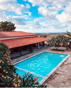 an image of a swimming pool in front of a house at Hotel Fazenda Monte Castelo Flat Gravatá in Bezerros