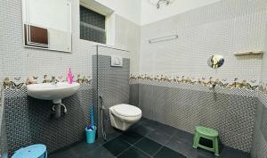 a bathroom with a toilet and a sink at Mystique Inn Wayanad in Vythiri