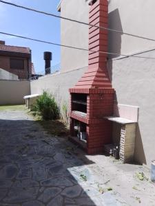 einem Backsteinofen im Freien neben einem Gebäude in der Unterkunft Casa grande en Mar del Plata, cochera, parrilla, parque, TV con wifii. IMPECABLE in Mar del Plata