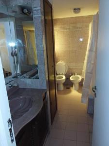 ein Badezimmer mit Waschbecken, Toilette und Spiegel in der Unterkunft Casa grande en Mar del Plata, cochera, parrilla, parque, TV con wifii. IMPECABLE in Mar del Plata