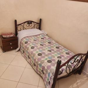 um quarto com uma cama com um edredão florido em B 1 apartment em Fez