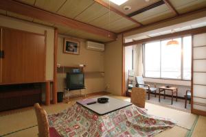 a living room with a table and a television at Yamadaya Hotel in Fujikawaguchiko