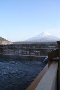 una presa de agua con una montaña en el fondo en Yamadaya Hotel, en Fujikawaguchiko