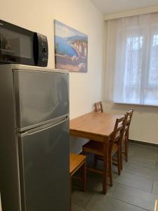 een keuken met een roestvrijstalen koelkast en een houten tafel bij Just Berlin - Wohnung für bis zu 12 Personen in Berlijn