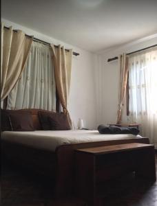 um quarto com duas camas com cortinas em Iarimbato Hotel em Antananarivo