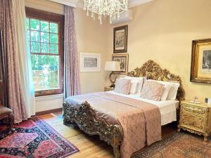 a bedroom with a bed and a chandelier at Villa Maria Pousada de Charme in Brotas