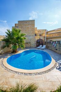 duży basen w podwórzu z budynkiem w obiekcie 5 Bedroom Farmhouse with Private Pool & Views w mieście Għarb