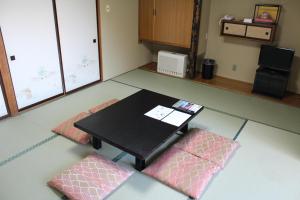 Habitación con mesa y 2 esteras rosas en Yamadaya Hotel, en Fujikawaguchiko