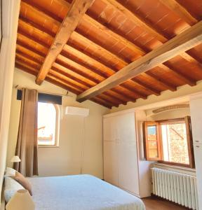 ein Schlafzimmer mit einem Bett und einer Holzdecke in der Unterkunft Berenice Housing in Prato