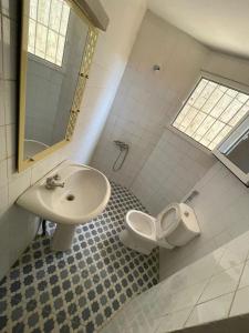 La salle de bains est pourvue d'un lavabo et de toilettes. dans l'établissement ParadisPlage, 1 min de la mer, à Saly Portudal