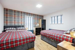 Un dormitorio con dos camas y una mesa y dos ventanas. en Ballycastle Bolthole, en Ballycastle