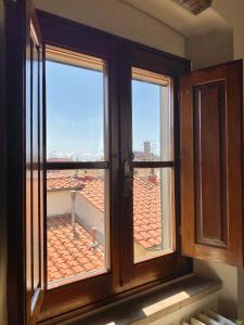 ein offenes Fenster mit Blick auf ein Dach in der Unterkunft Berenice Housing in Prato