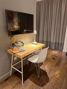 a wooden desk with a white chair and a table with a lamp at cool room in shared house in York